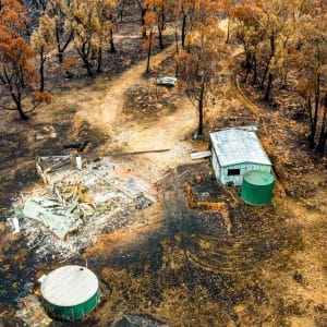 Aerial view of a fire-damaged rural property surrounded by burnt trees